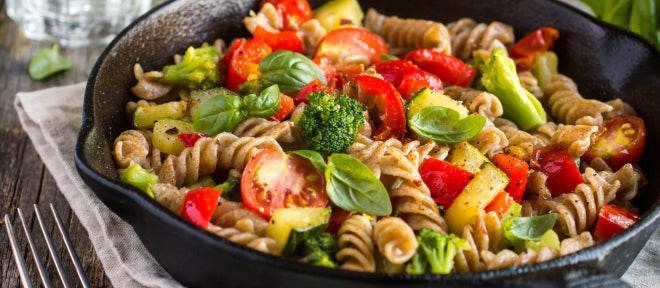 Pasta dish with vegetables in a black skillet